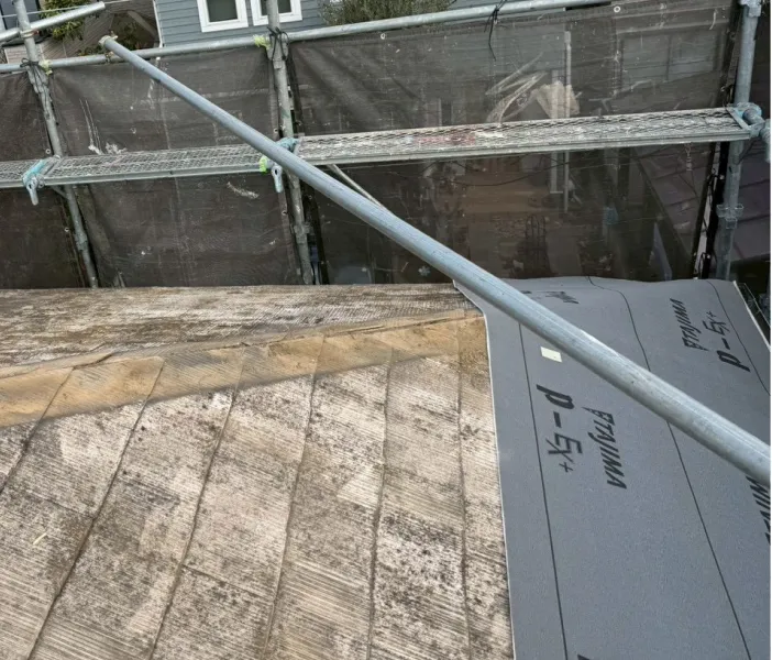 屋根カバー工法にて防水シートを貼っていく様子（川越市）