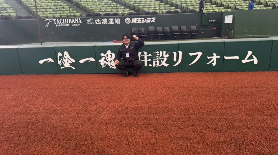 ベルーナドーム内のスポンサー掲出ロゴ前で撮影したKJリード代表の様子